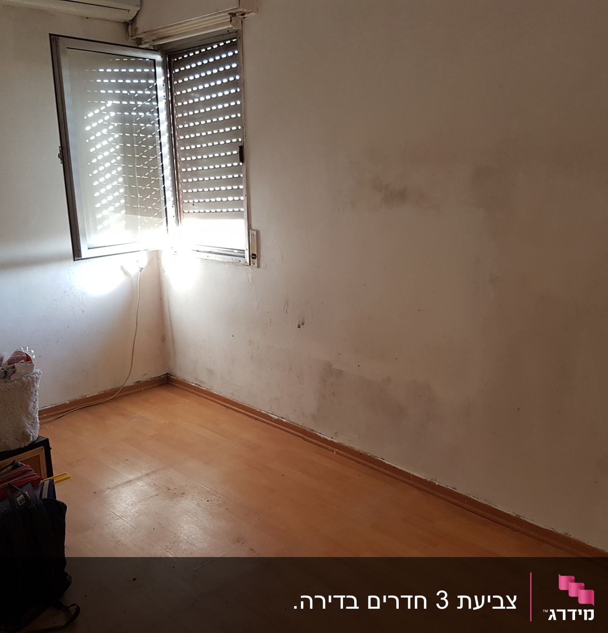 קיר עם סימני צבע, חלון פתוח, רצפת עץ